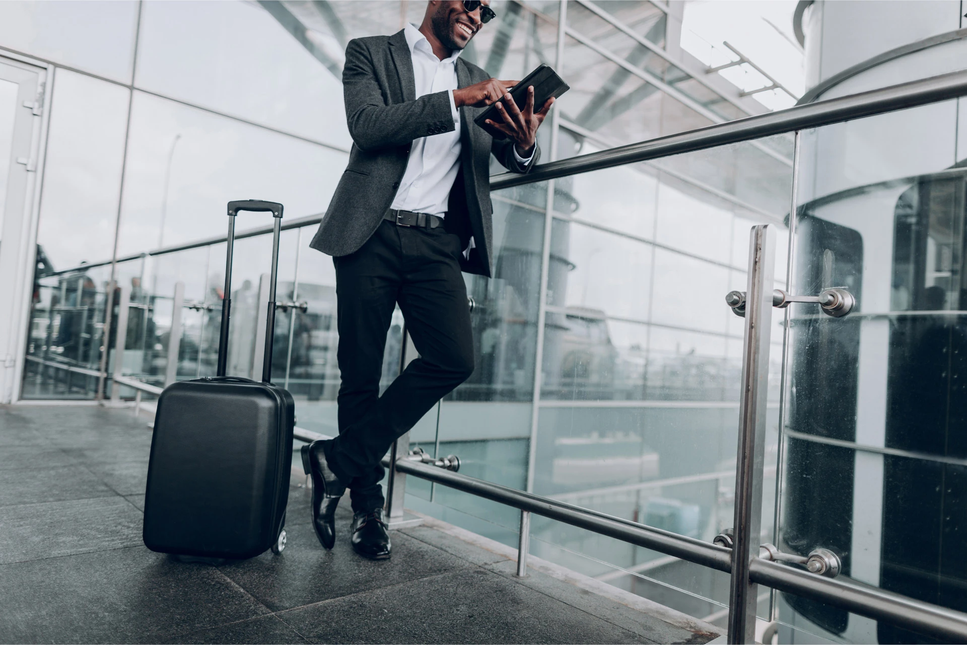 man with a suitcase and holding a tablet